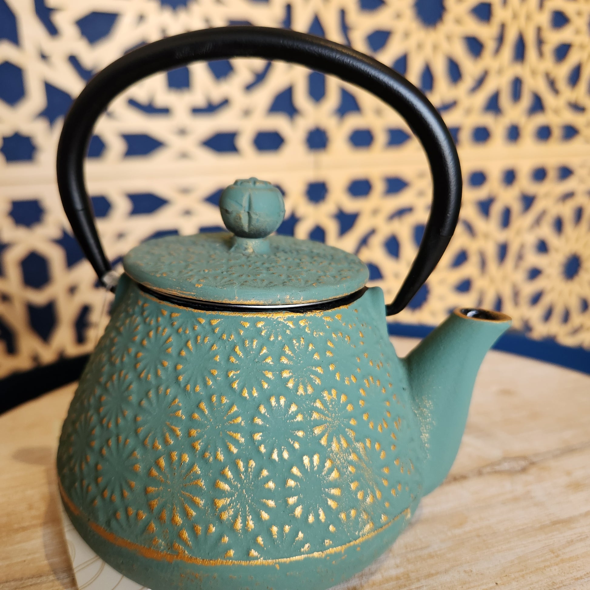 Green teapot with golden chrysanthemum pattern
