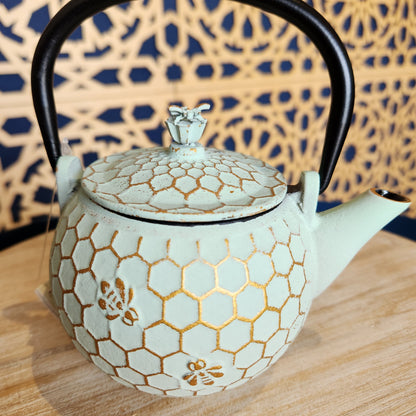 Light green teapot with a golden honeycomb and bee pattern