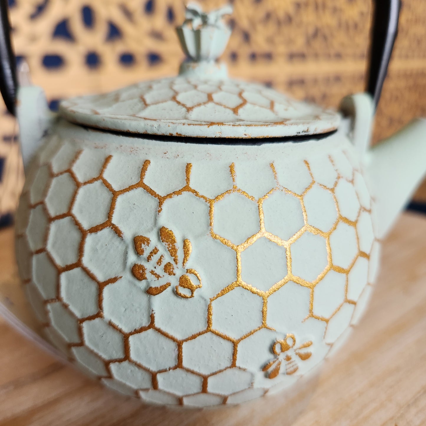 Close up of golden honeycomb  and bee pattern on teapot