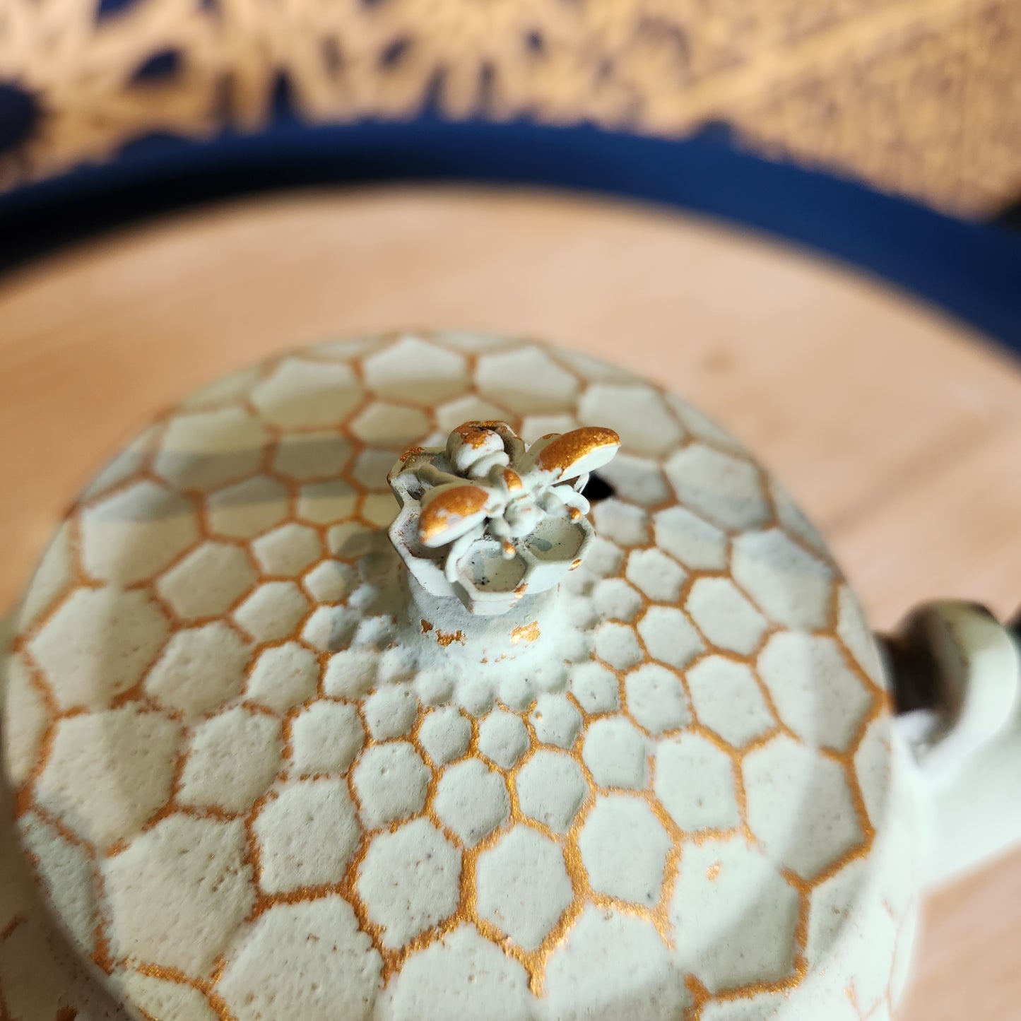 Close up of lid with a bee shaped handle on the honeycomb teapot