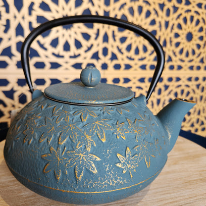Turquoise cast iron teapot with golden maple leaf pattern