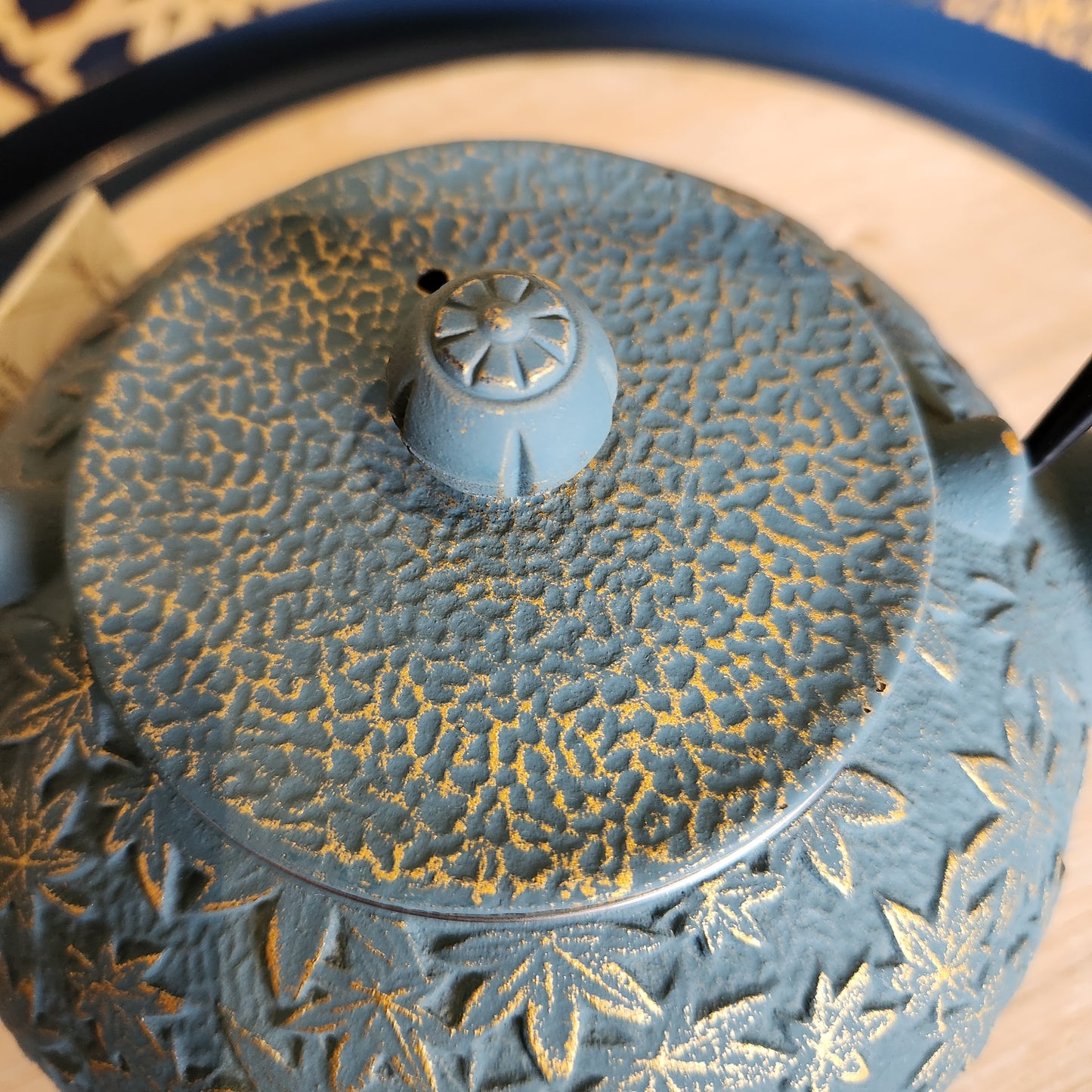 Close up of lid of turquoise teapot